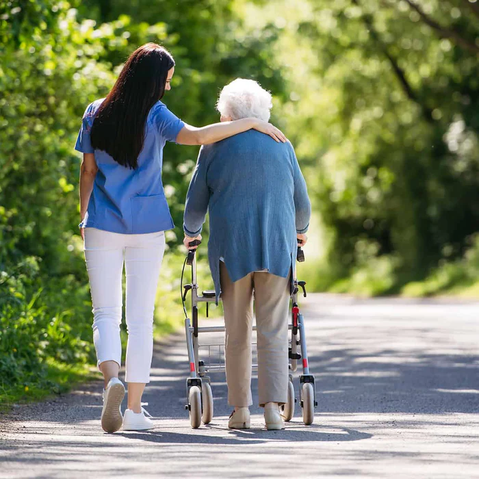 Female caregiver and senior woman with walker on walk in nature. ec9d0a2f 702c 4cd9 bd9b 132020106f32 700x700 crop center